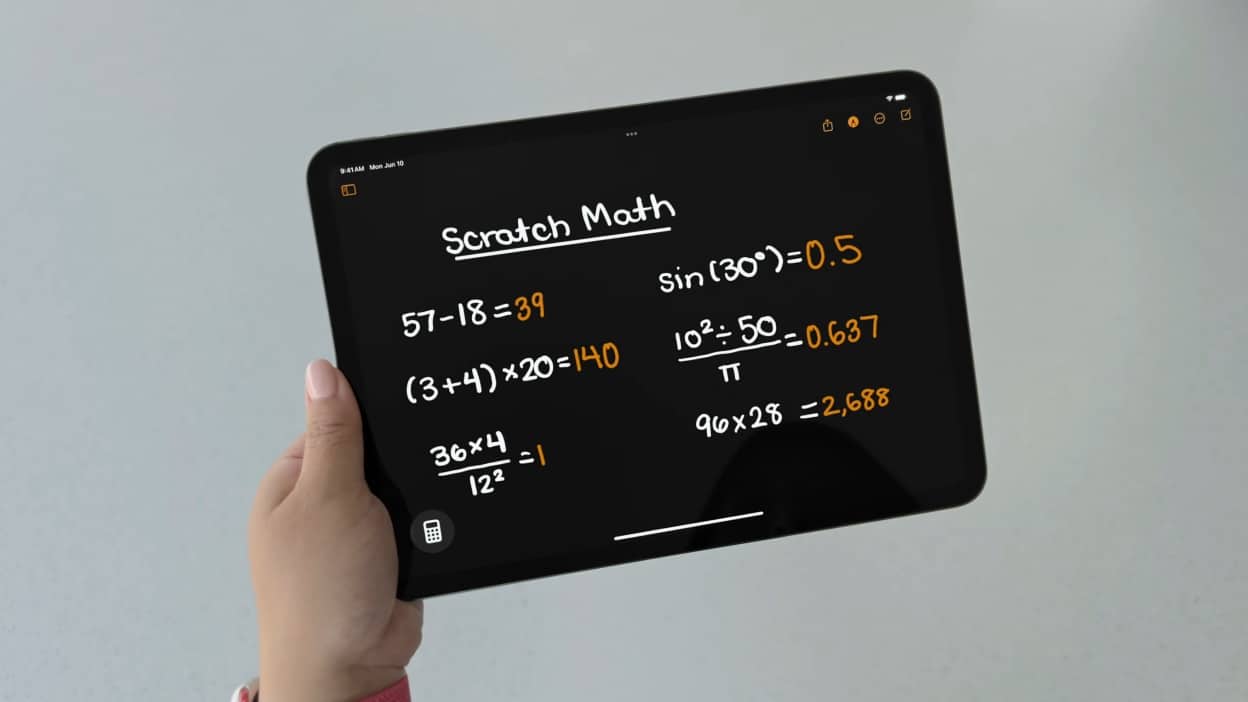 a hand holding a tablet with math equations on it