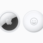 Two Apple AirTags rest on a white background. The left one proudly displays the iconic Apple logo surrounded by text, while the right features a charming smiley face. A small Apple logo graces the bottom corner, adding a touch of elegance to these innovative AirTags.