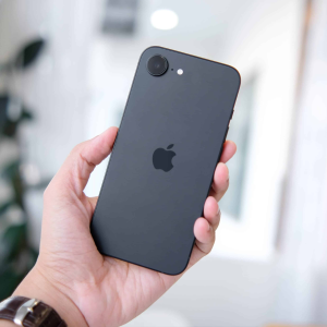 A close-up of the iPhone 16e, showcasing its 6.1-inch OLED display and single-lens 48-megapixel camera, set against a sleek, modern design resembling the iPhone 14, highlighting its role as Apple’s 2025 mid-range smartphone.